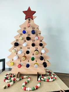 a wooden christmas tree with buttons on it