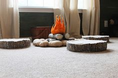 a fire pit sitting on top of a white carpeted floor next to two windows