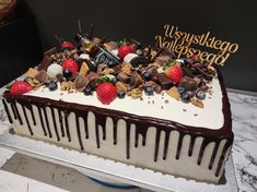 a large cake with chocolate and strawberries on top is sitting on a countertop