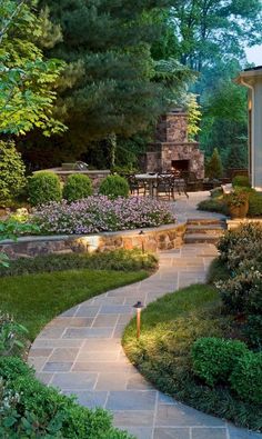 an outdoor patio with stone walkway and landscaping lighting