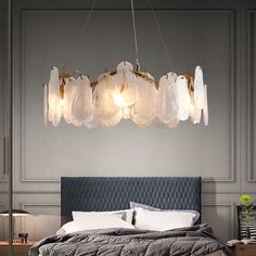 a large bed sitting under a chandelier in a bedroom