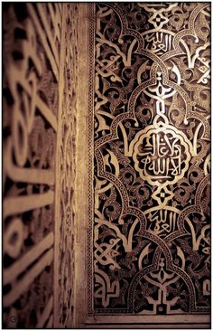 an intricately decorated wall with arabic writing on it