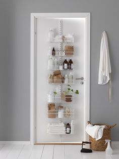 a white door with baskets and towels hanging on the wall next to an open closet