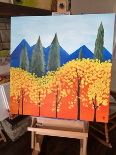 an easel holding up a painting with trees painted on it