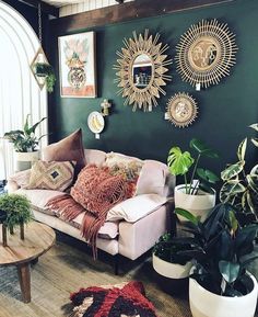 a living room filled with furniture and lots of plants on the wall next to it