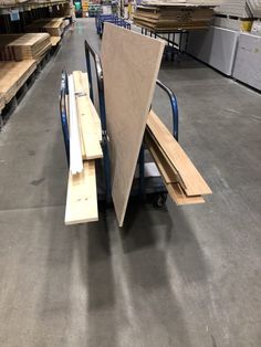 several pieces of plywood sit on a dolly in a warehouse