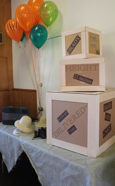 three boxes stacked on top of each other with balloons in the air above them, sitting on a table