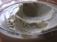 a glass bowl filled with whipped cream on top of a wooden table