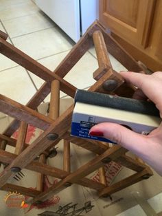 a person holding some kind of book in their hand near a chair made out of books