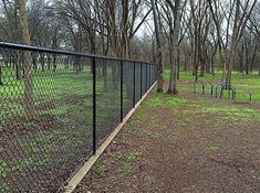 a fenced in area with trees and grass