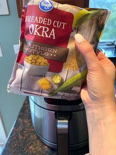 someone holding up a bag of breaded cut okra in front of an instant pot