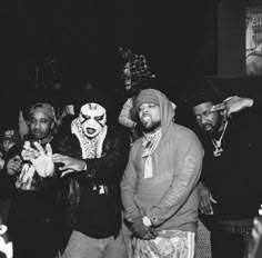 two men in clown masks standing next to each other with their hands up and one man pointing at the camera