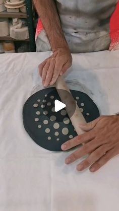 a man is using a large spatula to cut up something on a sheet of paper