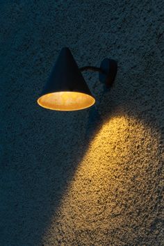 a wall light that is on the side of a building with sand all over it