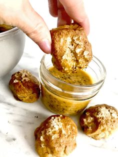 a person dipping some food into a jar