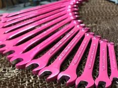 pink wrenches are lined up on a table