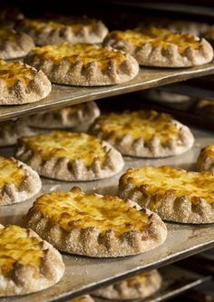 several trays filled with baked goods on top of metal pans in an oven