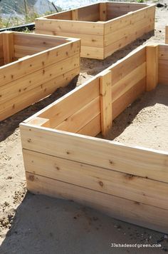 several wooden planters sitting in the sand