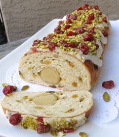 a white plate topped with a loaf of bread covered in jelly and pistachio