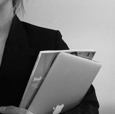 a woman holding an apple laptop computer in her hands