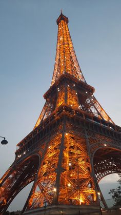 the eiffel tower lit up at night with lights on it's sides