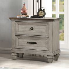 a nightstand with two drawers and a clock on the top one drawer is turned off