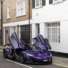 a purple sports car parked in front of a building