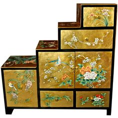 four boxes with flowers painted on them are stacked next to each other in front of a white background