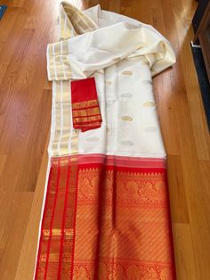 Exquisite Kanjiwaram Silk White and Red saree. Classic combination, it has silver gold zari,  ravishing border with peacock and rudraksh motif.   SILK MARK CERITIFIED  This Saree is ready to wear with fall and pico done.  Note. This is a handwoven saree and there might be slight inconsistency such as in it's weaving. Festive Saree With Border For Rituals, Katan Silk Temple Jewelry Dupatta For Wedding, Temple Jewelry Style Dupatta With Self Design, Handloom Anarkali For Rituals, Paithani Silk Dupatta With Self Design For Rituals, Self-design Paithani Silk Dupatta For Rituals, Self Design Paithani Silk Dupatta For Rituals, Traditional Drape Saree With Border For Rituals, Paithani Silk Dupatta For Rituals And Festivals