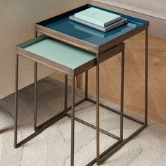 two metal and glass nesting tables on carpeted floor