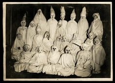 an old black and white photo with many people dressed up in halloween costumes, including ghost heads