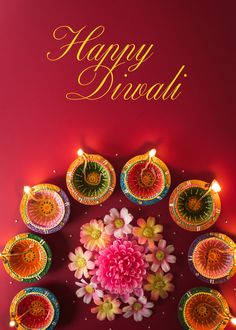 happy diwali greeting card with colorful flowers and candles in the center on a red background