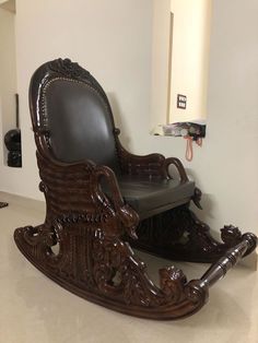 an ornate wooden rocking chair in the corner of a room with white walls and tile flooring