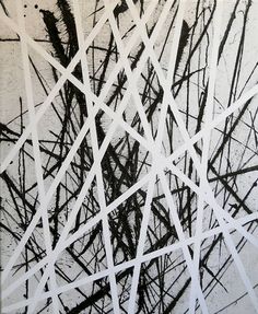 black and white abstract painting with lots of lines on the wall in front of it