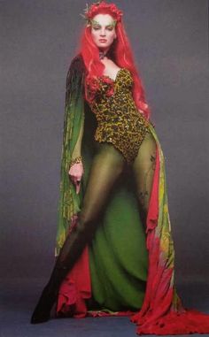 a woman with long red hair and green dress