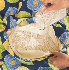 a person pouring white pearls into a bag