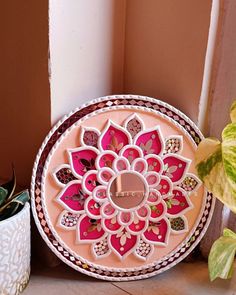 a decorative plate sitting on top of a table next to a potted plant