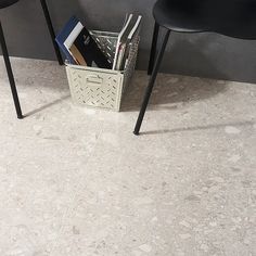 two black chairs sitting next to each other in front of a table with books on it