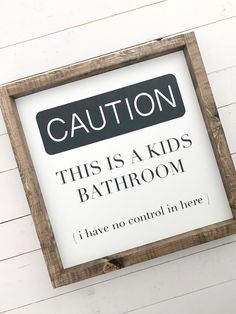 this is a kids bathroom sign hanging on the side of a white wall with wood planks