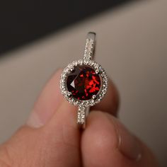 This is a gorgeous handmade creation. Its beauty is its simplicity & Elegance. The 7*7mm round cut natural garnet is crafted in solid sterling silver and with rhodium plated. All item is sent in a beautiful gift box You can realize more lovely stuff clicking the link https://www.etsy.com/shop/knightjewelry?refshopsection_shophome_leftnav Please leave the correct address and you phone number for delivering successfully. Engagement Rings Red, Garnet Engagement Rings, Rough Diamond Engagement Ring, Rings Red, Red Gemstone Ring, Rings Promise, Garnet Engagement Ring, Ring Inspo, Ruby Rings