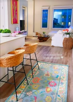 two wicker stools sit on the floor in front of an area rug