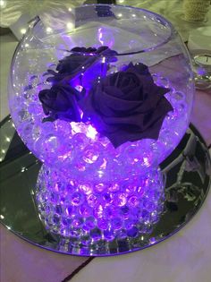 there is a purple rose in the center of this glass bowl with beads on it