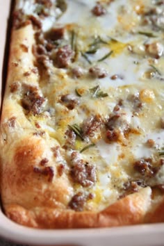 a close up of a pizza with cheese and meat