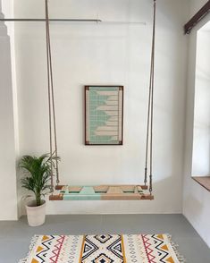 a room with a rug, potted plant and swing