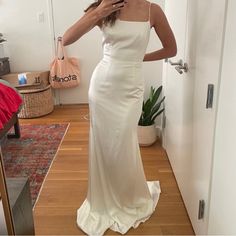 a woman in a white dress taking a selfie