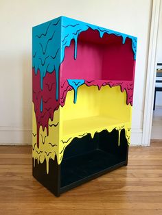 a colorful shelf sitting on top of a hard wood floor