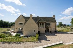 a large brick house sitting on top of a lush green field