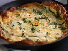 a cheesy dish with asparagus and cheese in a cast iron skillet