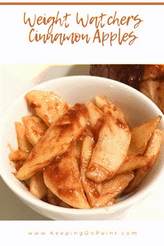 a white bowl filled with apple slices on top of a table next to some meat