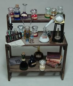 a shelf filled with bottles and candles on top of a table